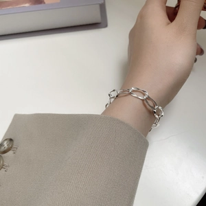 Detailed close-up of a S925 sterling silver long link bracelet worn on a female wrist