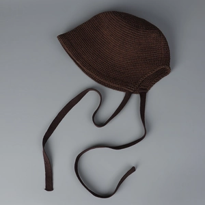 Detailed knit texture of dark brown crochet bucket hat with adjustable side ties