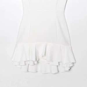White halter neck mini dress featuring layered ruffled hem and textured crepe fabric