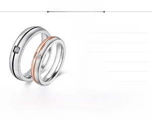 Detail of color-blocked stainless steel couple rings with single zircon stone inlay