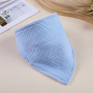 Detailed texture of light blue double-layer cotton gauze baby bandana bib on table