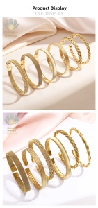 Close-up of woven titanium steel bangles with mesh and twist texture in gold plating