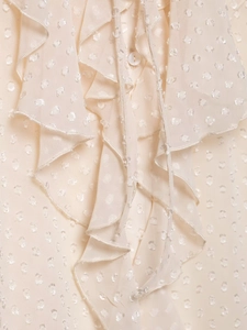Detail of apricot chiffon top with ruffle edges and textured polka dot jacquard fabric