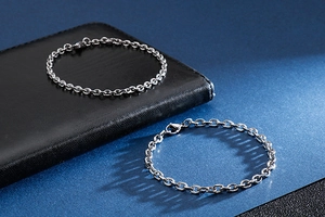 Detail view of silver thick and thin punk chain bracelets on professional dark background