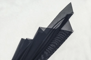 Detailaufnahme der geschichteten schwarzen Mesh-Stoffstruktur für figurbetontes Kleid