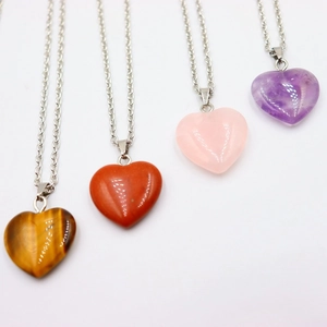 Detail of heart-shaped natural stone pendants in tiger eye, quartz, and amethyst on chains