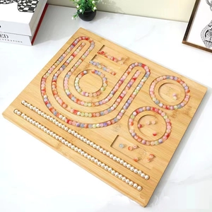Wooden beading tray for jewelry making with organized colored beads on a white desk