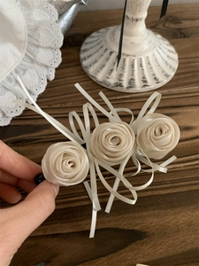 Détails de roses en satin crème faites main et rubans sur une pince à cheveux rétro