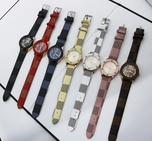 Flat lay of vintage women's quartz watches with plaid leather straps in various colors