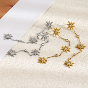Close-up of starburst drop earrings with gold and silver plating and sparkling zircons