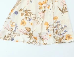 Close-up of floral sunflower print and ruffled hem craftsmanship on chiffon dress