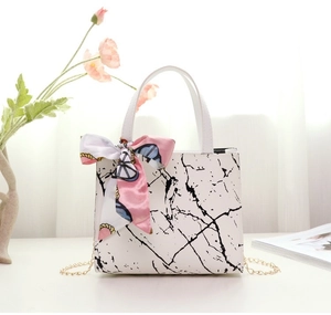 Detailed shot of white marble pattern tote bag with gold chain and silk scarf decor