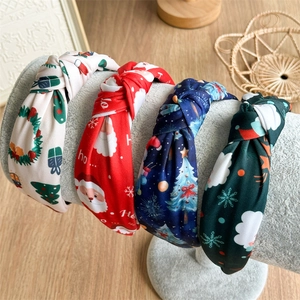 Set of 4 Christmas knotted headbands with festive patterns on a display stand