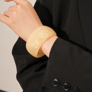 Macro shot of thick cream yellow marble resin bangle showing semi-transparent texture