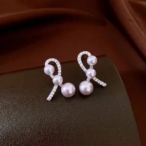 Silver bow earrings with sparkling cubic zirconia and soft lavender pearls in a refined style