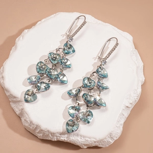 Détail de boucles d'oreilles vintage avec zircons bleu sarcelle sur fond de pierre