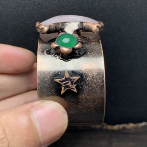 Detailaufnahme der Vintage-Bronzemanschette mit grünem Stein und geprägtem Stern