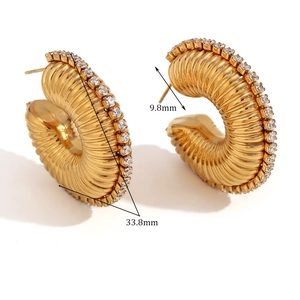 Macro detail of gold hoop earrings with zircon edges and pleated texture showing dimensions