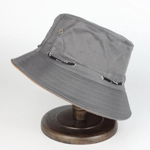 Détail d'un chapeau de soleil gris foncé avec œillets métalliques et cordon sur un support