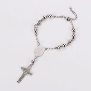 Detail of rosary chain bracelet with silver cross pendant and engraved icon medal charm