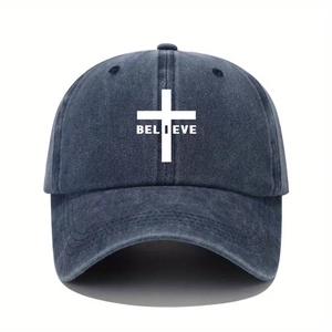Close-up of BELIEVE text and cross print on washed denim baseball cap surface
