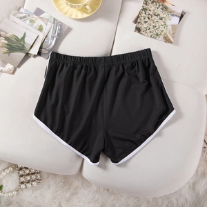 Close-up of black elastic sports shorts with white trim and flexible high waist fabric