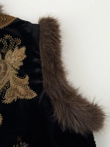 Detail of gold beaded embroidery on black velvet vest with brown fur trim decoration