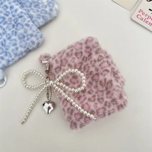 Detail der rosa Plüschtasche mit Leopardenmuster, Perlenbogen und Herzanhänger aus Silber