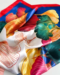 Detail view showing the soft satin texture and ginkgo leaf print on this silk-like scarf