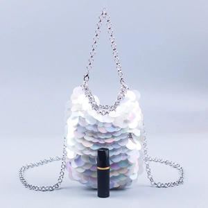 Detail shot of iridescent sequin bag with silver chain and lipstick for size reference