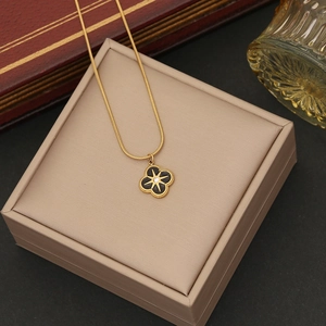 Detailed close-up of a gold star flower necklace pendant on a beige jewelry box