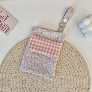 Detailed view of floral pink nurse pocket organizer with snap button strap and grid flap