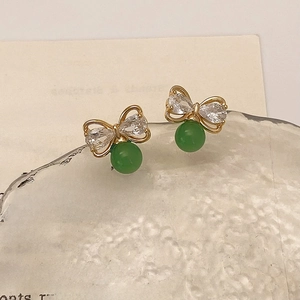 Détail de la boucle d'oreille en nœud avec perle verte et oxydes de zirconium brillants