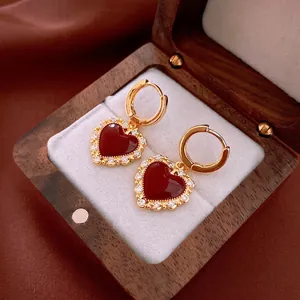 Elegant gold plated heart earrings with red enamel and shimmering cubic zirconia stones