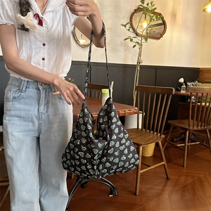 Detail of vintage floral canvas tote featuring green hearts on black cotton fabric