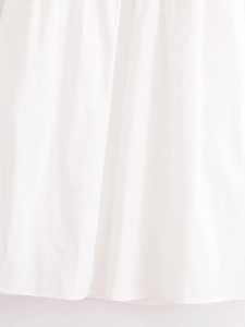 Detailed view of the hem stitching and premium white cotton fabric of the midi dress