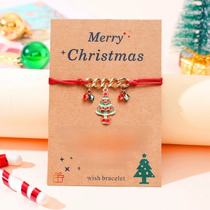 Christmas wish bracelet with red rope and enamel tree pendant on a greeting card