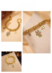 Detail of gold-plated stainless steel chain bracelet with Hamsa Hand and Evil Eye charms
