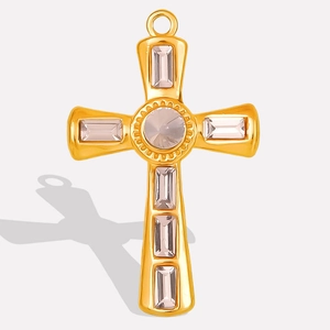 Detail view of a gold cross pendant with light pink crystals and polished finish