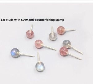 Detail view of S999 sterling silver ear studs featuring a certified authenticity hallmark