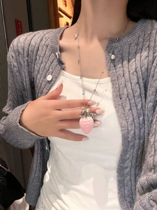 Detail of pink strawberry pendant necklace with white pearls on a silver metal chain
