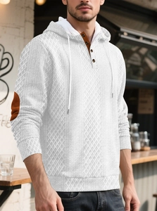 Détail d'un sweat à capuche en jacquard blanc avec patte de boutonnage et coudières brunes