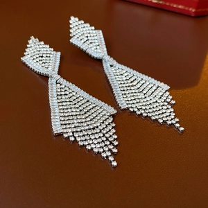 Makroaufnahme von silbernen Quastenohrringen mit kleinen Diamanten auf dunklem Grund