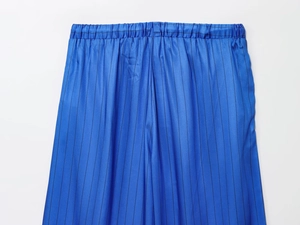 Detailed view of elastic waistband and blue pinstripe fabric on casual trousers