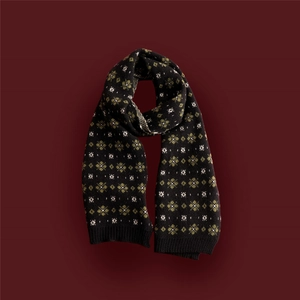Detailed view of the soft black knitted scarf with green and white geometric patterns