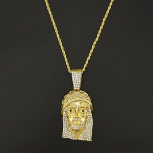 Iced out gold Jesus head pendant necklace with diamonds on a sleek black background