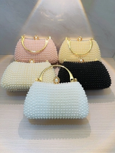 Detail of handmade pearl evening bags with gold handles in five elegant colors