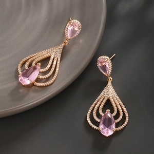 Detail of rose gold earrings featuring pear-shaped pink stones and pavé set zircons