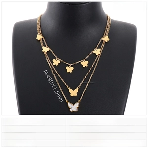 Detailed view of layered stainless steel gold necklace with sparkling crystal butterfly charms
