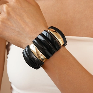 Detailed view of bold chunky acrylic resin and gold metal link bracelet on wrist